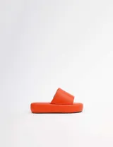 Sandalias de plataforma color naranja, con tira ancha sobre el empeine y suela gruesa.