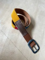 Cinturón de cuero marrón con apliques de tela aguayo con motivos geométricos multicolores.