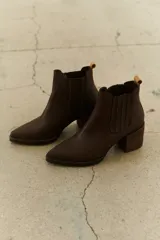 Bota de cuero color café, con punta afilada y tacón ancho.