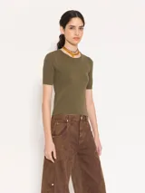 Top tejido en hilado frío color verde militar, con calce al cuerpo, mangas cortas y abertura en la espalda que se ata en el cuello.