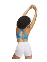 Top deportivo Under Armour color verde agua, con espalda cruzada y logo de la marca en la banda inferior.