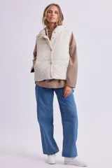 Chaleco puffer negro con cierre frontal con botones a presión y cuello alto.