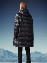 Campera larga de alta tecnología color negro, con diseño acolchado y capucha ajustable.