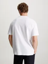 Remera blanca de algodón con cuello redondo y logo Calvin Klein nano estampado en el pecho.
