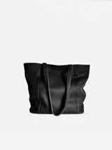 Tote de cuero negro con cierre, bolsillo interior y porta llaves, ideal para uso diario.