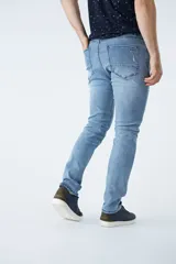 Pantalón jean celeste de corte recto, con cintura regular y tiro medio. Tiene roturas y logo bordado.