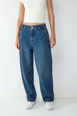 Pantalón jean azul oscuro de corte ancho, estilo skater, con cierre de cremallera y botón, y cuatro bolsillos.