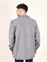 Sobrecamisa gris de manga larga con cuello clásico, cierre frontal con botones y dos bolsillos con solapa en el pecho.