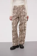 Pantalón de mezclilla con estampado de serpiente en tonos marrones y beige, de corte holgado.