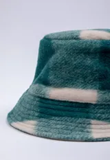 Bucket hat de textura suave con estampado a cuadros en tonos verde y beige.