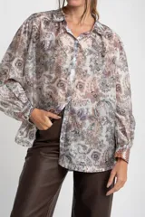 Camisa oversize de mangas largas con puños abotonados, cuello clásico y cierre frontal con botones. Estampado con motivos paisley en tonos pastel.