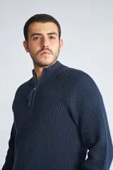 Sweater borgoña de punto acanalado, con cuello alto y medio cierre frontal.