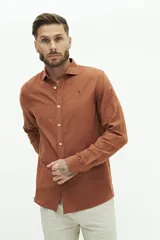 Camisa de lino color beige, de manga larga, corte semi slim y logo bordado en el pecho.