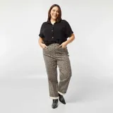 Camisa negra de lino con botones blancos, mangas cortas con dobladillo y cuello clásico.