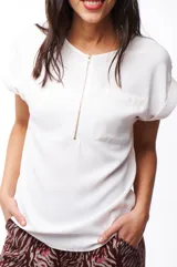 Blusa blanca de poliéster con cierre dorado en el escote y mangas cortas.