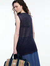 Musculosa sin mangas color gris, tejida en hilado con brillo sutil. De calce relajado y largo por debajo de la cadera, presenta aberturas laterales.