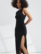 Vestido midi negro de punto, sin mangas, con cuello redondo y abertura lateral en la falda.