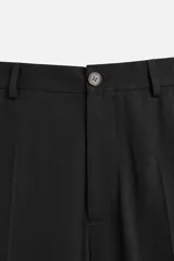 Pantalón negro de corte recto confeccionado en tejido fluido con mezcla de viscosa, con bolsillos frontales y traseros de vivo.