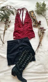 Body de encaje color vino, con escote pronunciado en la espalda y broches a presión.