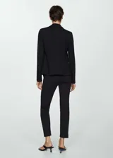 Pantalón negro de vestir, de corte recto, con cierre de cremallera y gancho, tiro medio, trabillas y bolsillos laterales y traseros.