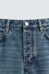 Pantalón de jean celeste de corte recto, con cinco bolsillos y cierre frontal con botones.