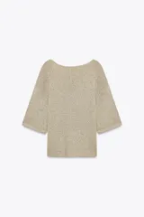 Top color beige de tejido de punto, con cuello redondo y mangas cortas tipo capa.