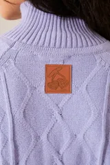 Polera de punto en color fucsia, con diferentes texturas, cuello alto y mangas largas.