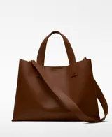 Bolso tipo tote grande color marrón, con doble asa de mano y correa larga extraíble. Interior con dos compartimentos y bolsillo central con cierre.