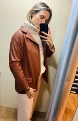 Blazer de cuero sintético color chocolate con cuello solapa y bolsillos con tapa.