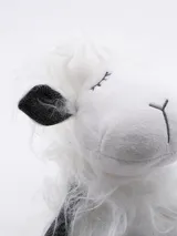 Oveja de peluche blanca con detalles en negro.