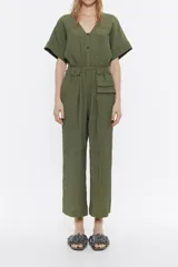 Mono largo color verde militar, de viscosa con textura, escote en V, manga corta, cierre frontal con botones a presión, bolsillos laterales y cintura fruncida con elástico.