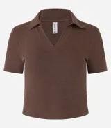 Blusa de punto acanalado (rib) color marrón oscuro, con cuello polo, escote en V y manga corta.