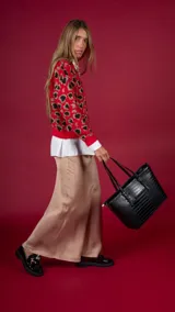 Cartera de simil cuero negro con textura de reptil, diseño elegante y asas largas.