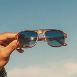 Lentes de sol Sunski Shoreline con montura cuadrada color marrón y lentes polarizados grises que bloquean el 100% de los rayos UVA/UVB/UV400. Fabricados con polímero reciclado SuperLight.
