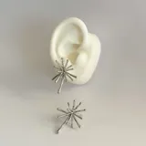 Par de caravanas plateadas de acero quirúrgico hipoalergénico con forma irregular.