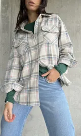 Sobrecamisa de cuadros en tonos beige y azul, con bolsillo frontal y corte holgado.