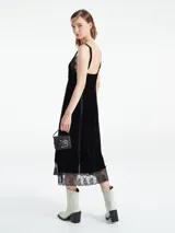 Vestido largo verde esmeralda de terciopelo con breteles finos regulables y escote en V. Detalles de encaje negro en escote y ruedo.