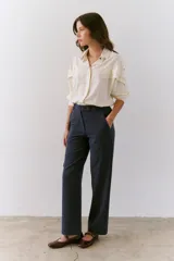 Camisa color azul de corte suelto, con detalles en las mangas y cuello clásico.