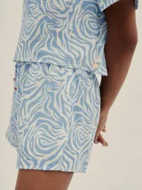 Conjunto de short y remera con estampado abstracto en tonos celeste y blanco. El short tiene pretina con elástico y detalle de Polonio en cobre.