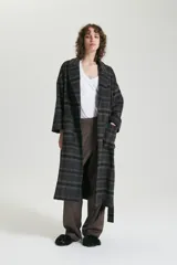Tapado largo con diseño a cuadros en tonos gris, marrón y negro. Tiene cuello solapa, bolsillos laterales y lazo para ajustar en la cintura.