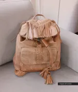 Mochila de cuero color camel con solapa con flecos y cierre con cordón de cuero.