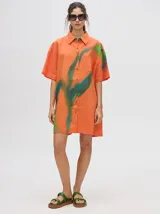 Camisa vestido naranja con estampado abstracto en verde y azul. De corte holgado y mangas cortas.