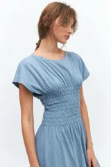 Vestido midi celeste con cuello redondo, mangas cortas y cintura elastizada con punto panal.