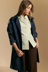 Camisa blanca de manga corta con volumen en los hombros, cuello camisero y cierre frontal con botones dorados.