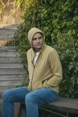 Campera con capucha de toalla de algodón color verde azulado, con cierre frontal y bolsillos laterales.