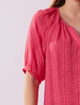 Blusa blanca de algodón marca Zac & Rachel, con cuello a la base, escote en V, abertura central con botones y sisa con aplique calado.