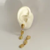 Aros colgantes dorados con tres piezas irregulares con textura martillada unidas por pequeñas argollas.