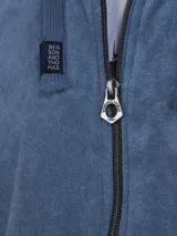 Campera con capucha de toalla de algodón color verde azulado, con cierre frontal y bolsillos laterales.