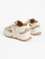 Zapatillas urbanas blancas con detalles en negro, cordones negros y suela chunky.