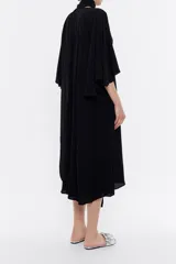 Vestido midi negro de viscosa fluida con escote en V, mangas 3/4 con vuelo, canesú fruncido en la espalda y lazos extralargos para cruzar en el cuello.